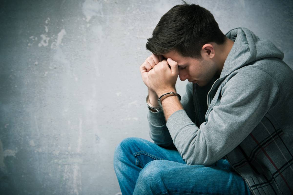 Depressed young man sitting with head in hands